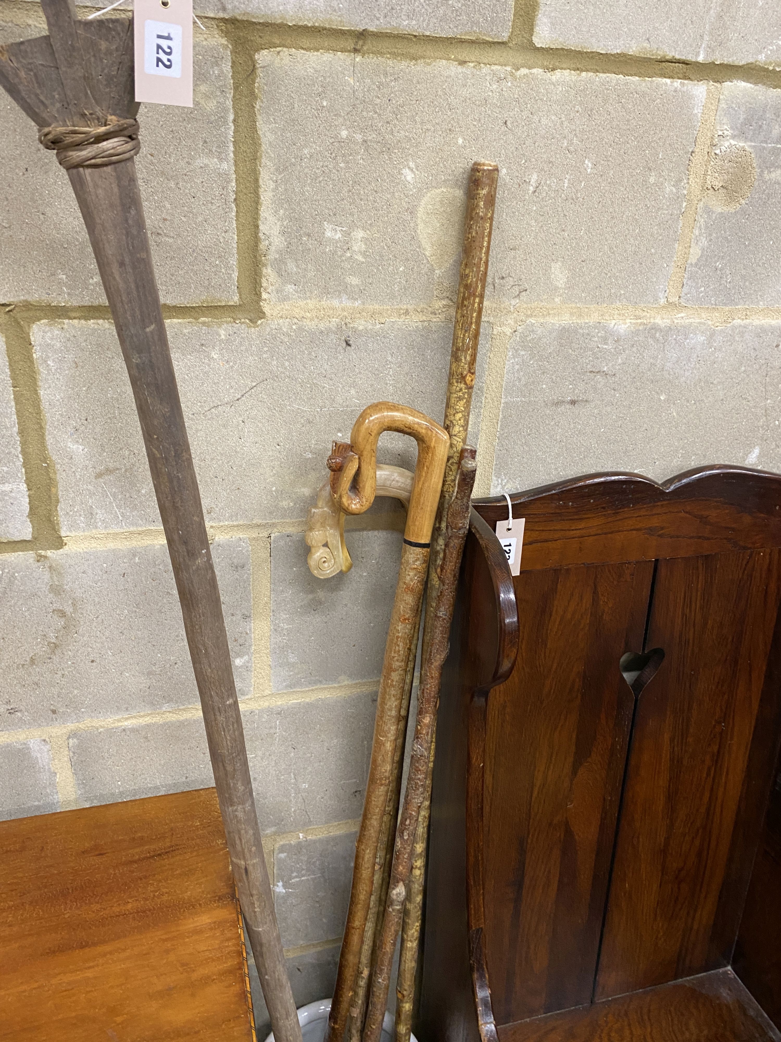 Four assorted walking sticks and canes, a primitive wood rake and a Chinese stick stand